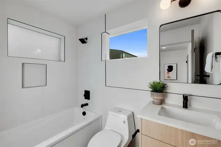 Full bathroom on entry level features a deep soaking tub and stylish vanity.