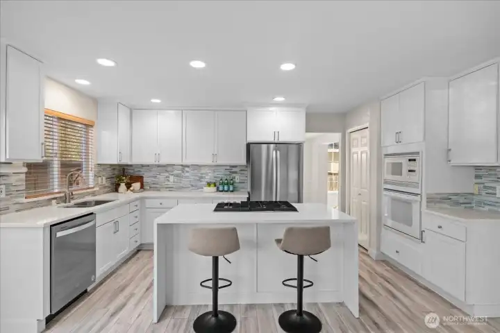 This kitchen will motivate you to cook and entertain with a large island featuring quartz waterfall counters, newer gas range, newer dishwasher and brand new refrigerator