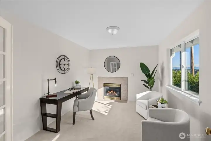 This is the sitting room off the primary bedroom - featuring double doors and a gas fireplace