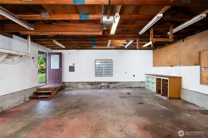 Little garage has overhead double door and exterior door into side yard.