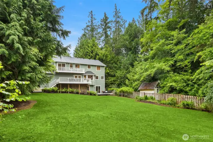 The home faces south toward a huge lawn for endless enjoyment.  (Note the magical little cottage behind the fence.)