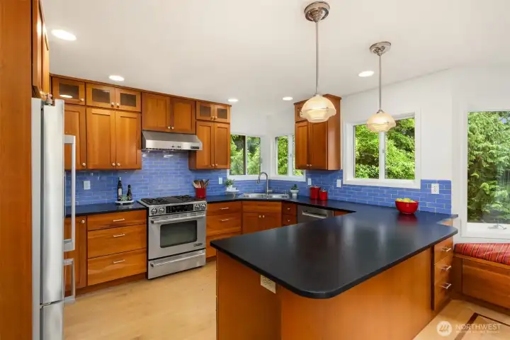 The owners remodeled the kitchen with custom cabinetry, Irish Black Silk Granite from India and lovely blue Ann Sacks tile.