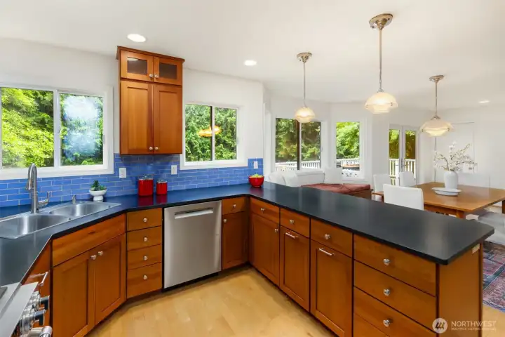 On the other side of the breakfast bar is the light-filled dining area and Anderson French doors leading to the deck for al fresco dining.