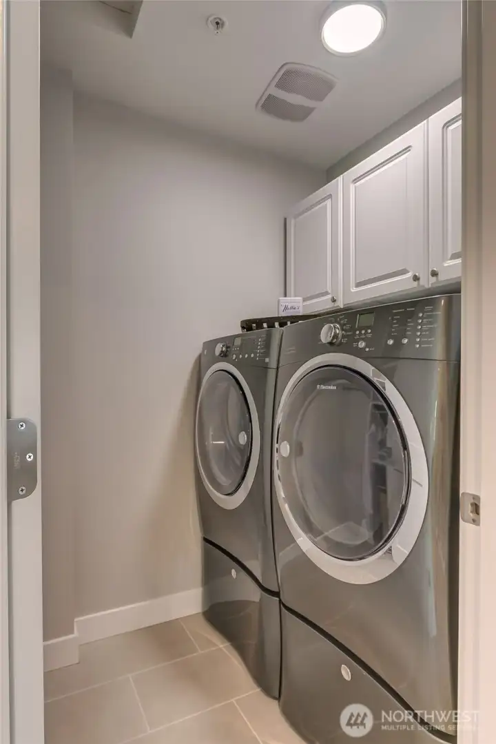 Upstairs laundry room with Electrolux appliances and ironing station