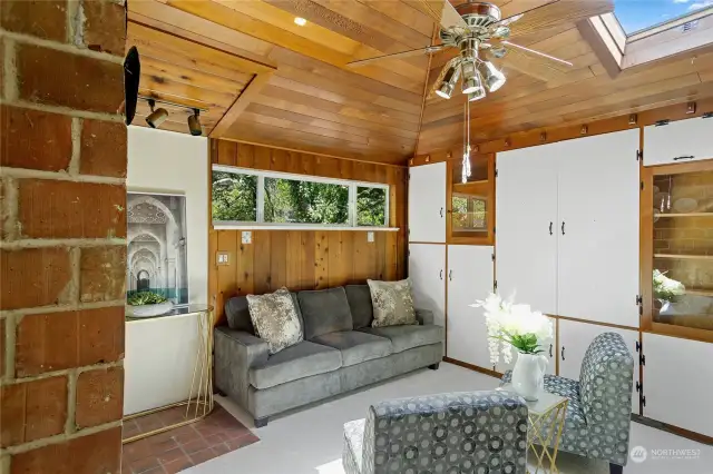 Earlier owners converted their attached garage into this light-filled spacious den that features built-in cabinets and shelves, a delightful skylight window and real knotty pine paneling.  The laundry area, along with the home's tankless water heater and access to the attic are at the back of this room.