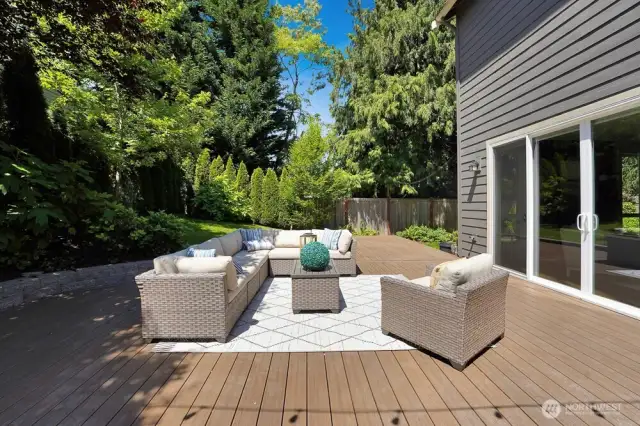 A large Trex-like deck offers both durability and elegance, seamlessly blending with the surrounding garden. From the garden’s perspective, the deck becomes a welcoming extension of the home, providing ample room for relaxation and entertaining