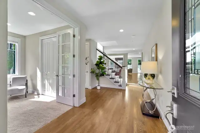 Stepping inside, you're welcomed by beautiful white oak hardwood floors that flow seamlessly throughout the main level, adding warmth and character to the space. The office, distinguished by its elegant French doors and ample closet space, offers versatility—it could easily serve as a main-floor bedroom with the adjacent well-appointed 3/4 bath featuring a shower