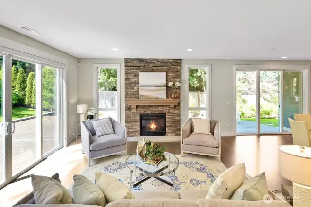 This bright and inviting family room seamlessly connects to the beautiful Trex-like deck, offering a zero-maintenance outdoor retreat. The beautiful stone gas fireplace serves as a striking focal point, adding warmth and character to the room
