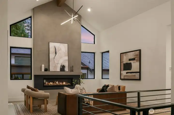 This great room impresses with 17-ft ceilings, a sleek 62” Napoleon Vector fireplace, a fir-wrapped glulam beam, and built-in surround-sound speakers