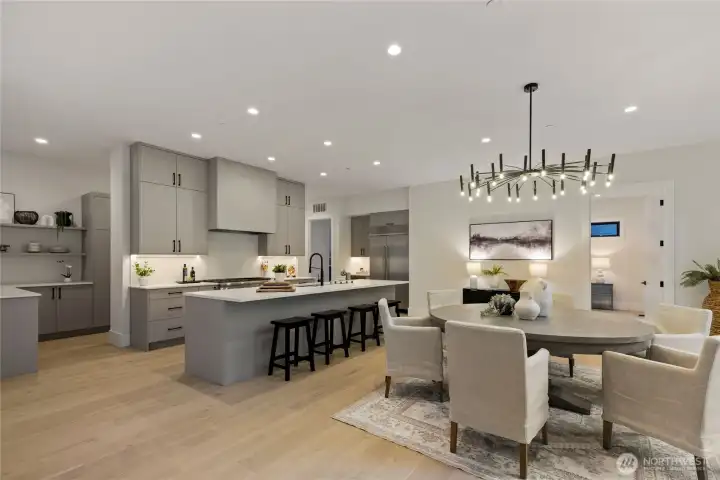 Chef's kitchen with Bellmont cabinets, large quartz island with seating and dining area