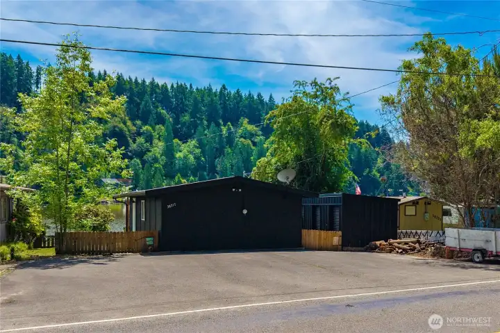 Cabin view from the road.  Freshly painted and fenced.  This cabin has a large level parking area which is hard to come by on Ohop Lake.