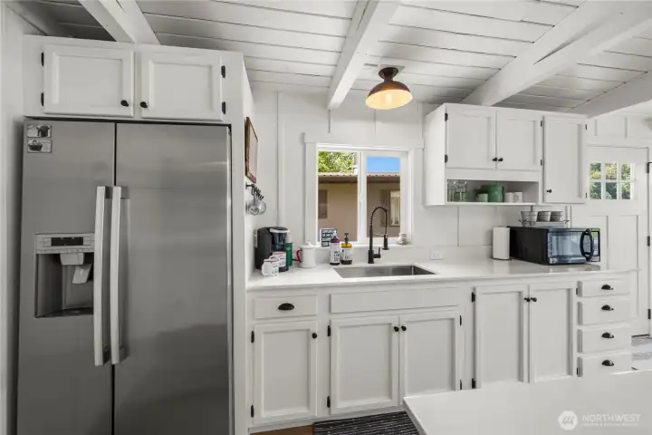 Fully updated kitchen with stainless fridge with quartz countertops.