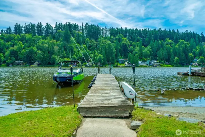 Lake view from the yard. To the right of the dock is a sandy beach area.
