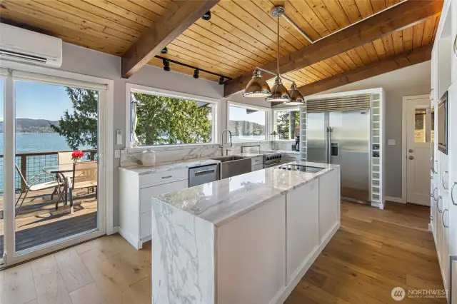 Bright filled kitchen with high end appliances and marble countertops.