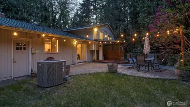 This spacious and charming backyard is surrounded by beautiful greenery.