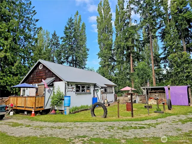 Looking at the house from the SW, you can see the little private yard space. There are several wood sheds and storage sheds around the property.