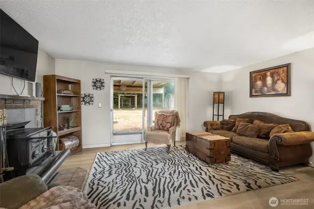 Living room with wood burning stove inset and direct access to the patio area.
