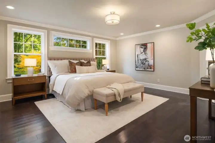 pacious primary suite featuring rich hardwood floors, abundant natural light, and a serene neutral palette.