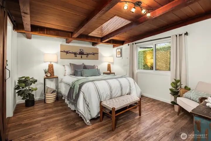 Large bedroom with exposed cedar and open beams.