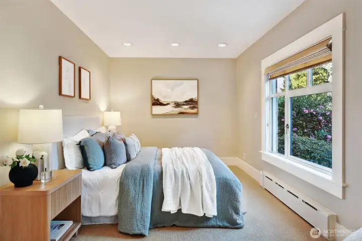 Main floor bedroom tucked on the east side looking over the beautiful front yard and garden space