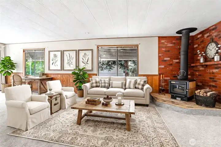 Family room with a fireplace and sliding door to the south facing wrap around deck with lake views.  Virtually staged photo.