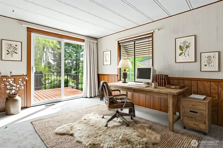 Family room with a fireplace and sliding door to the south facing wrap around deck with lake views.  Virtually staged photo.