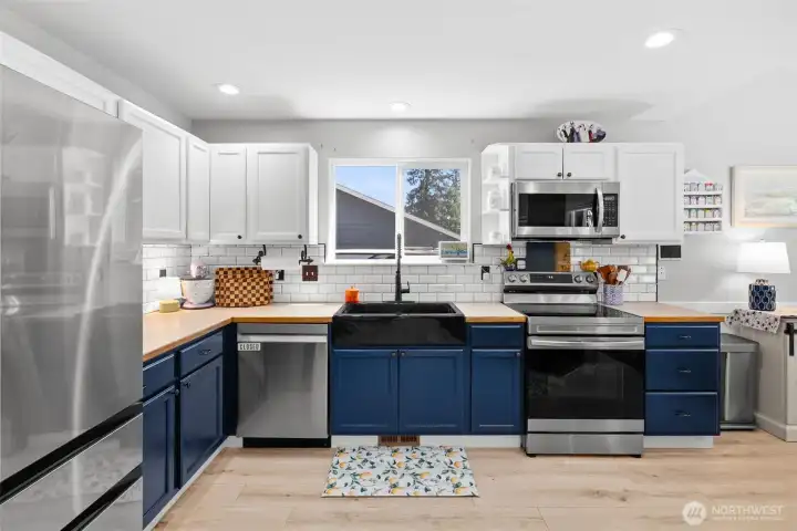 Beautiful two-toned kitchen features a new backsplash and recent appliances.