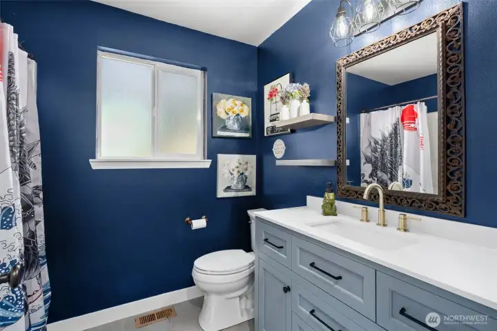 Hall bath has been updated with new vanity with quartz counter and ceramic flooring.