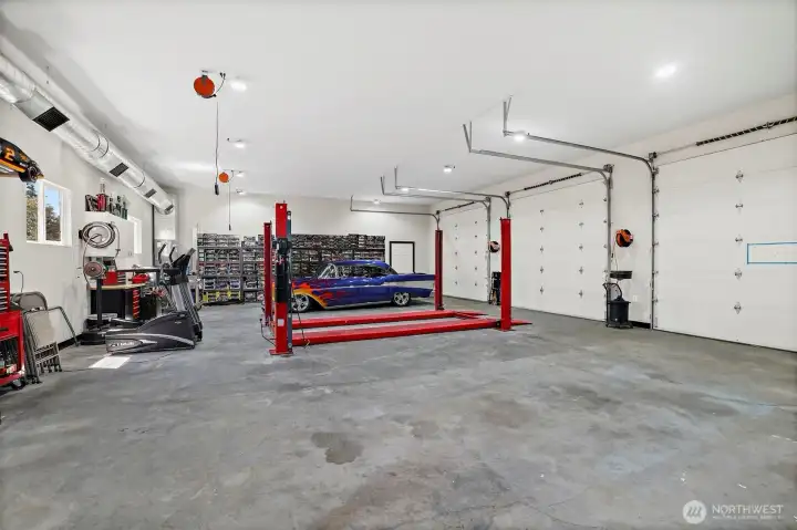 Detached garage/shop has updated LED lighting, retractable electrical outlets in the ceiling and comes with  a car lift