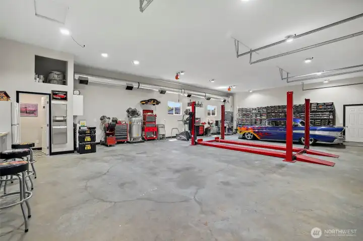 Detached garage/shop has a commercial-style air compressor system with integrated in-wall air lines and four retractable hose reels