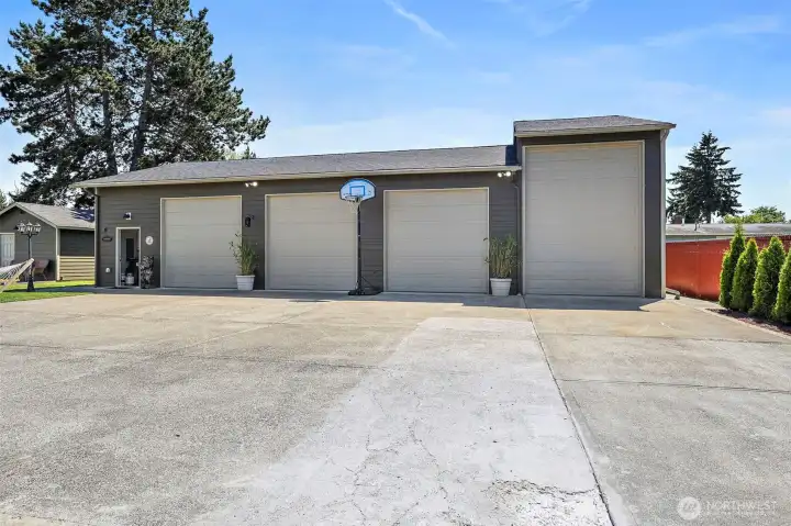 Deep 3 bay detached garage in back with attached fully enclosed High Bay; has 30amp plumbed for RV plug in