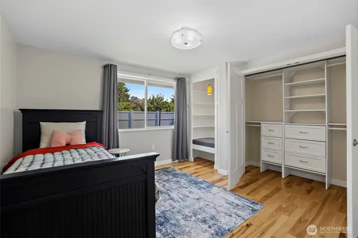 Oversized bedrooms with built in sitting nook with shelves and closet organizing systems in 3rd bedroom