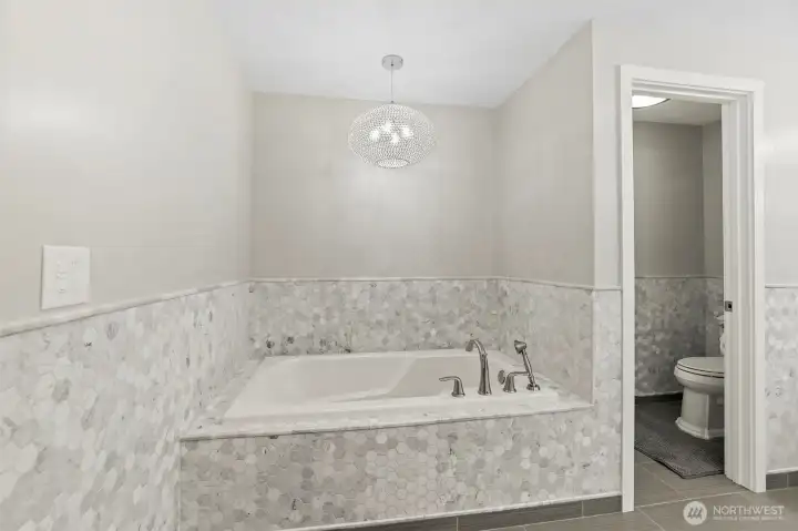 Primary suite soaker tub, dual sink vanity, and toilet closet. Main bathroom has  sun tunnel (solar tube); Mozaic Tile in all Bathrooms;