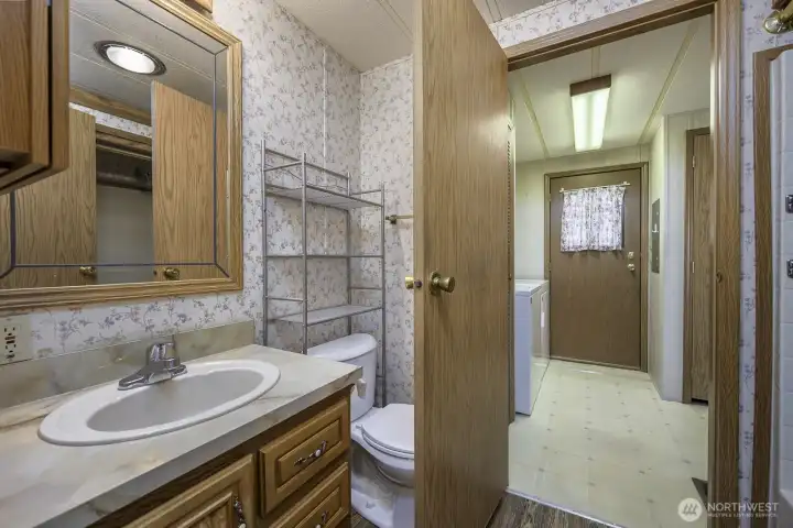 Guest Bath with access from the hall, laundry room, and back door.