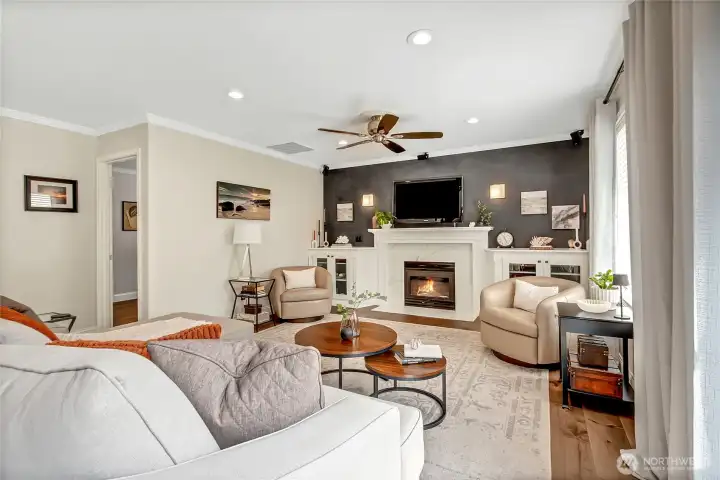 Family room offers custom built-ins with glass doors flanking a gas fireplace with a Dekton stone surround and wood mantel. Dimmable sconces, a Bose surround sound system, hard maple flooring, and an under-stair storage closet with shelving, lighting, and an outlet for vacuum add both syle and function. Family room offers custom built-ins with glass doors flanking a gas fireplace with a Dekton stone surround and wood mantel. Dimmable sconces, a Bose surround sound system, hard maple flooring, and an under-stair storage closet with shelving, lighting, and an outlet for vacuum add both syle and function.