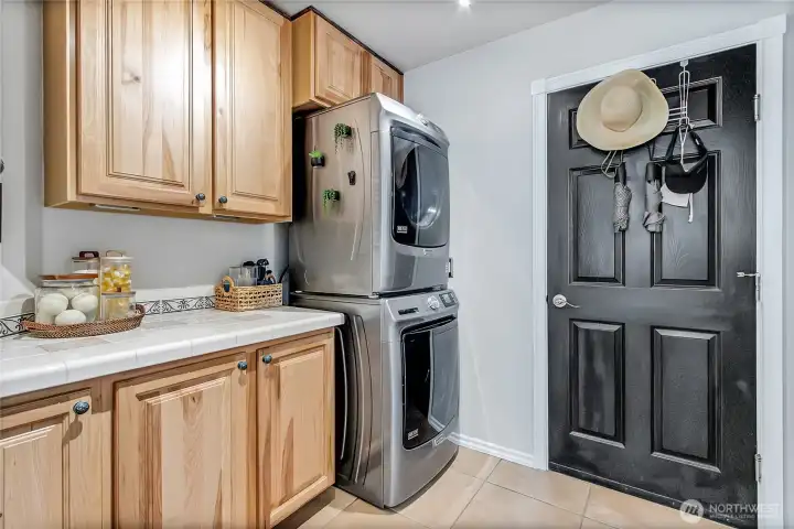 Laundry room with solid hickory cabinet doors, custom accessories for sorting, LED lighting, a hanging rod for delicate garments and finished with porcelain tile. Laundry room with solid hickory cabinet doors, custom accessories for sorting, LED lighting, a hanging rod for delicate garments and finished with porcelain tile.