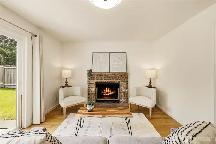 Family room featuring a fireplace, hardwood floors, and large windows that bring natural light into the heart of the home. Family room featuring a fireplace, hardwood floors, and large windows that bring natural light into the heart of the home.