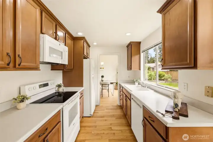 Bright kitchen featuring ample storage, efficient workspace, and easy access to dining and gathering areas. Bright kitchen featuring ample storage, efficient workspace, and easy access to dining and gathering areas.