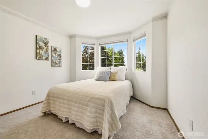 Bright secondary bedroom featuring large windows and a comfortable layout. Bright secondary bedroom featuring large windows and a comfortable layout.