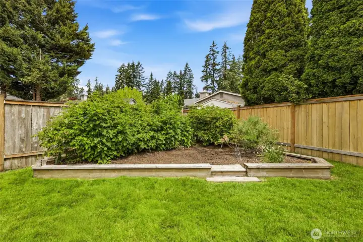 Garden area featuring mature landscaping with space for growing flowers, vegetables, berries, and seasonal plantings. Garden area featuring mature landscaping with space for growing flowers, vegetables, berries, and seasonal plantings.