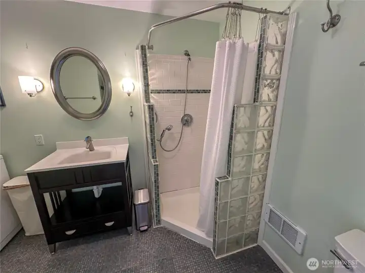 Another view of the fun tile and glass work adorning the bathroom. The ceramic tile flooring continues into the bathroom as well.