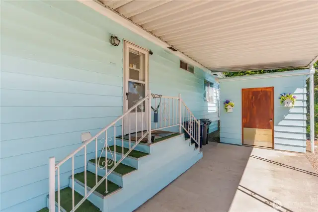 Back entrance with a storage shed and covered parking