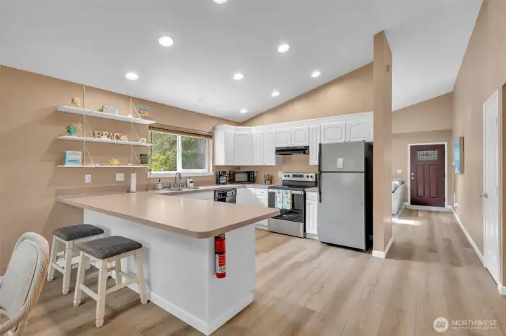 Bright white kitchen cabinets and breakfast bar. All stainless steel appliances included!