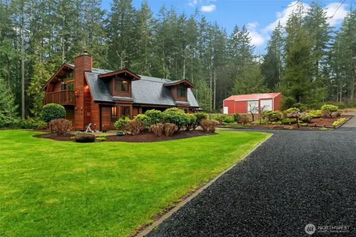 The approach to the property highlights a thoughtful site plan, where the home and outbuilding sit in perfect architectural harmony.