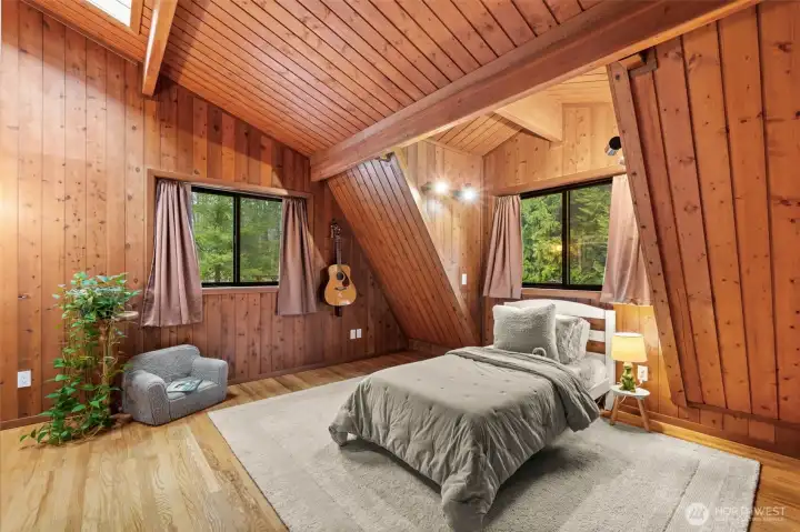The ultimate 'treehouse' vibe. Being surrounded by natural wood creates an immediate connection to the forest outside, perfect for a peaceful night's rest in this secondary bedroom.