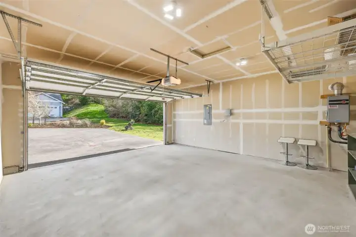 Rheem gas, tankless water heater on display in the two-car garage. Overhead storage rack.
