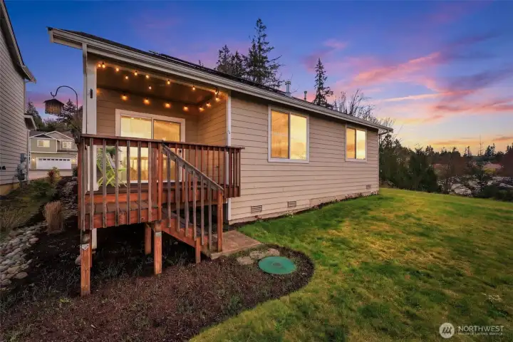 Back of home with a roughly 8x10 deck. The lid is not for septic, this home is connected to sewer.