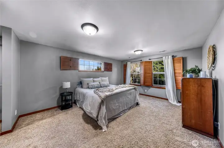 Primary bedroom provides a spacious retreat  with calming views and comfortable  proportions. Neutral tones enhance natural  light and create a restful environment.