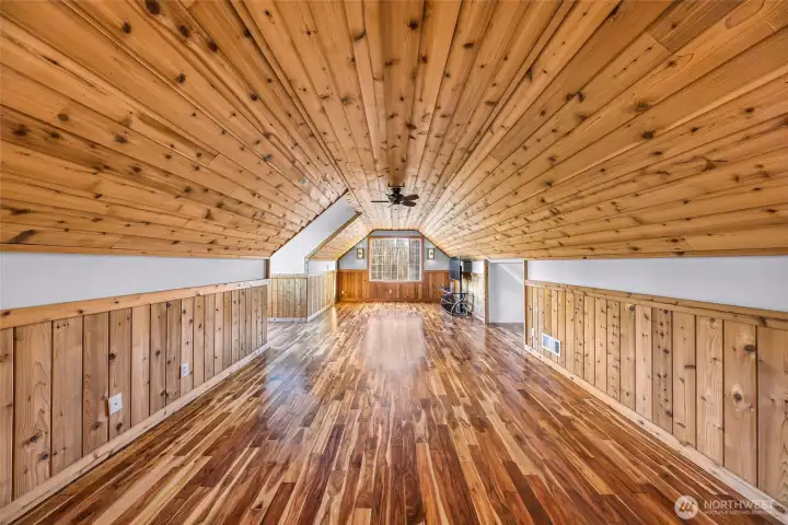 Expansive bonus room with wood-plank  ceiling adds flexible living space ideal for  recreation, hobbies, or multi-purpose use.  The scale and finish make it a standout  feature of the home.