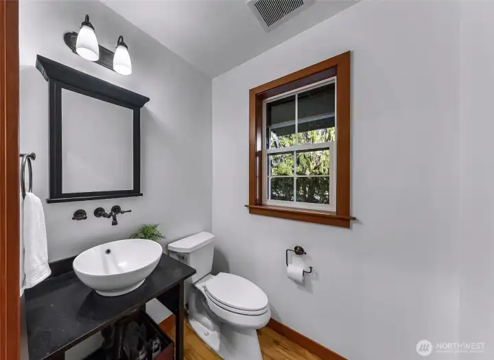 Main-level powder room features clean  finishes and convenient access for guests.  Practical and well-maintained.